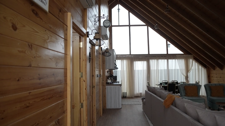 كوخ خشبي داخلي مع نوافذ كبيرة، لقطة داخلية.