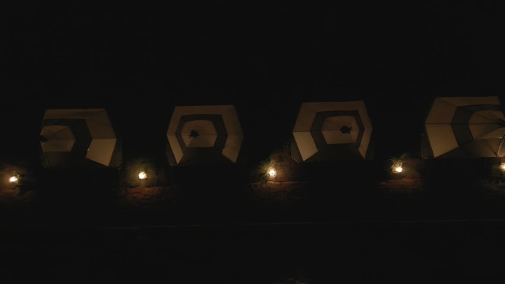 أكواخ مضاءة في الليل في منتجع، لقطة ليلية.