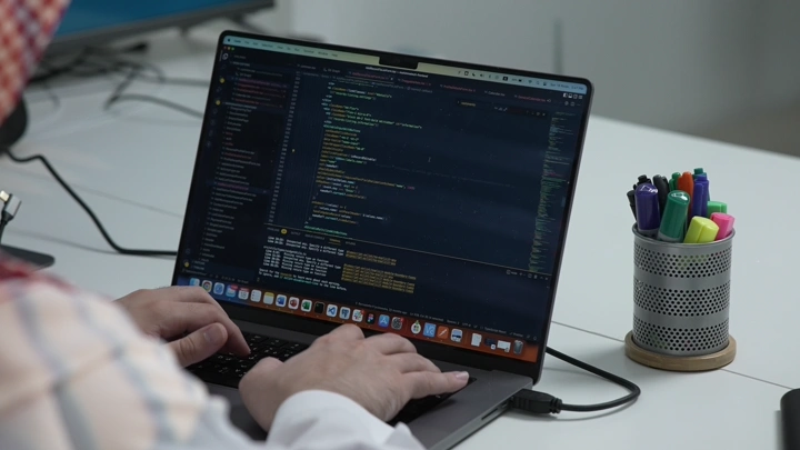 شخص يعمل على حاسوب محمول في مكتب حديث، لقطة مقربة.