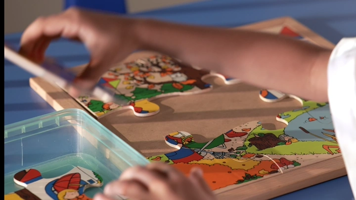 طفل يلعب بأحجية خشبية على طاولة، لقطة مقربة.