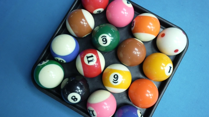 كرات بلياردو ملونة في مربع على طاولة زرقاء، لقطة علوية.