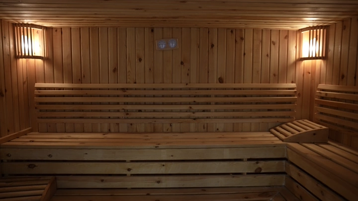 غرفة ساونا خشبية بإضاءة دافئة، لقطة داخلية.