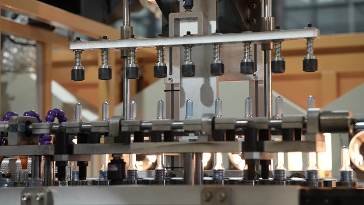 آلة تعبئة زجاجات في مصنع مياه، لقطة مقربة.