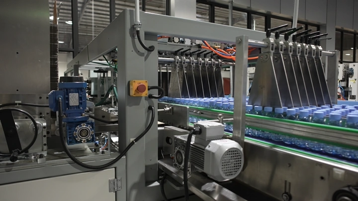 خط إنتاج زجاجات مياه في مصنع، لقطة داخلية.