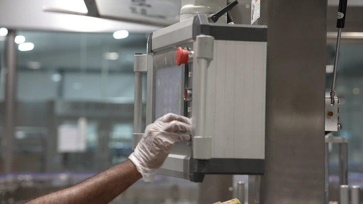 عامل يتحكم في لوحة في مصنع مياه، لقطة مقربة.