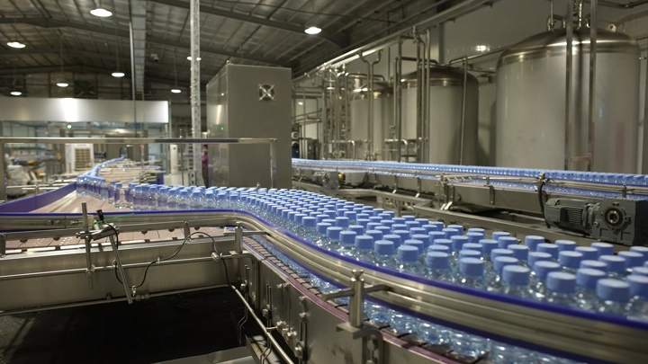 خط إنتاج علب مياه في مصنع، لقطة داخلية.