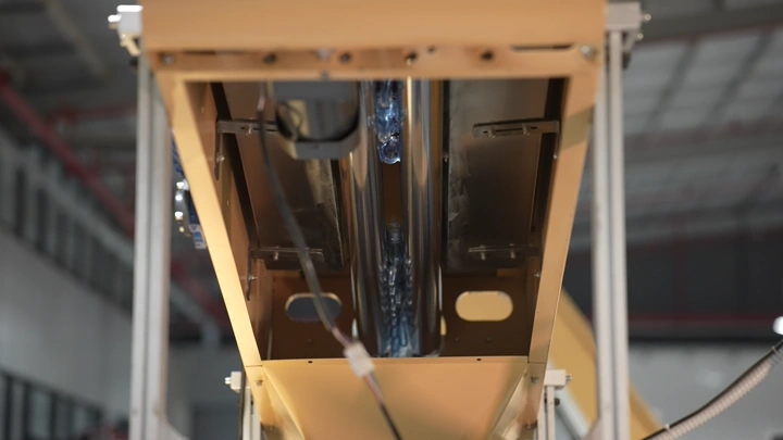 آلة تعبئة زجاجات في مصنع مياه، لقطة قريبة.