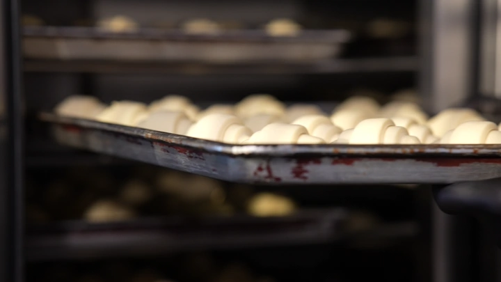 كرواسون غير مخبوز على صينية في فرن، لقطة مقربة.