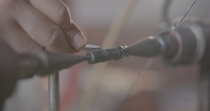 يد تصنع سبحة في ورشة عمل، لقطة قريبة.