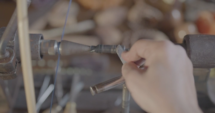 يد تصنع سبحة في ورشة عمل، لقطة مقربة.