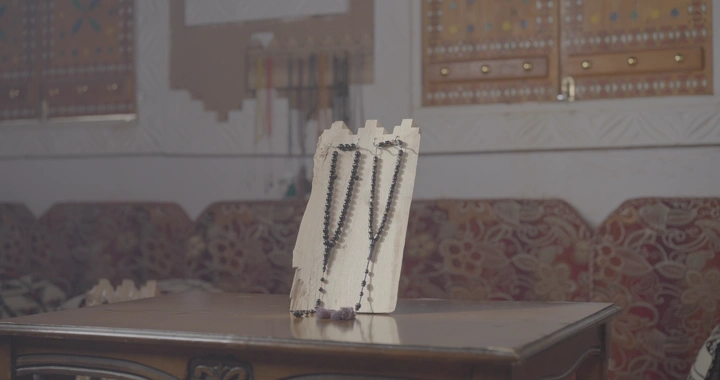 سبحة معروضة على طاولة خشبية في غرفة تقليدية، لقطة داخلية.