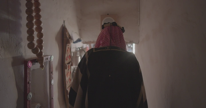 شخص يرتدي زي تقليدي في متحف أثري، لقطة من الخلف.