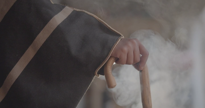 يد تمسك عصا خشبية في متحف أثري، لقطة مقربة.