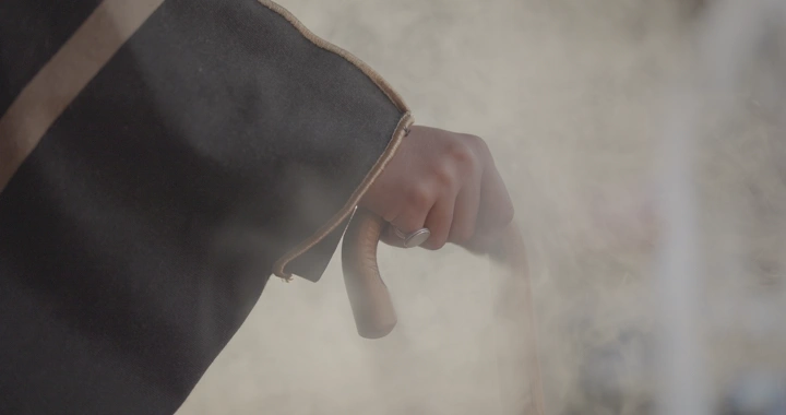 يد تمسك بعصا في مشهد ضبابي، لقطة قريبة.