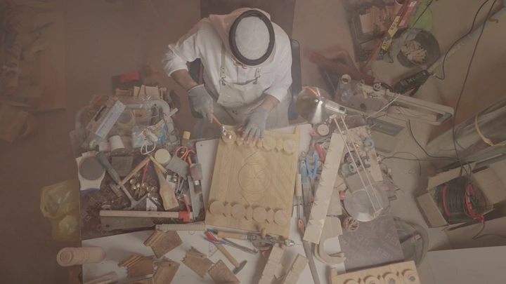 حرفي يعمل على تصميم باب خشبي في ورشة، لقطة من الأعلى.