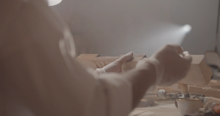 عامل يصبغ الخشب في ورشة، لقطة قريبة.