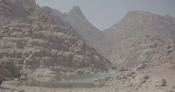 جبال الكشرية في حائل مع بركة ماء، لقطة نهارية.