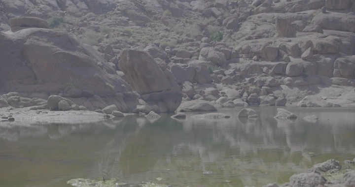 جبال الكشرية بحائل مع بركة ماء، لقطة نهارية.