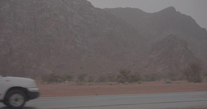 سيارة تسير أمام جبال سد السلف في حائل، لقطة نهارية.