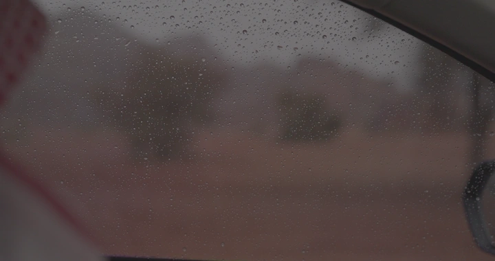 نافذة سيارة مع قطرات المطر، تصوير من الداخل.