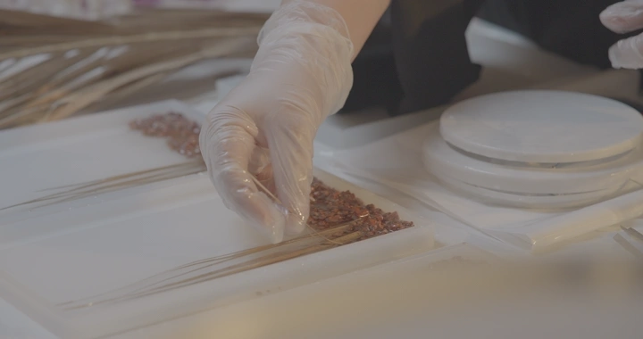 يد تضع مواد في قالب ريزن، لقطة مقربة.