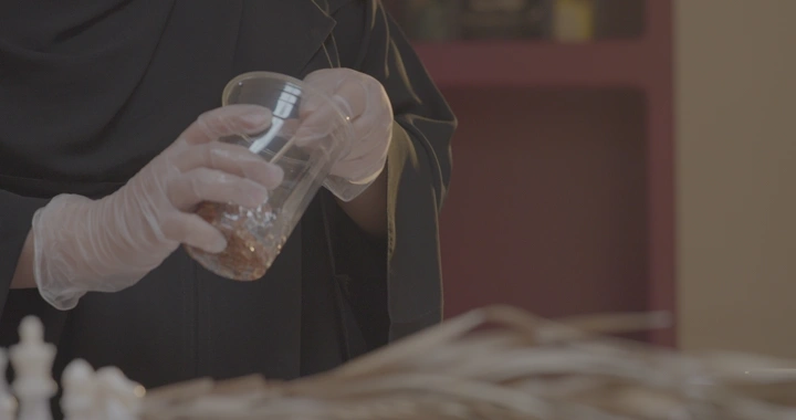 امرأة تصنع تحفًا من الريزن في الداخل، لقطة مقربة.