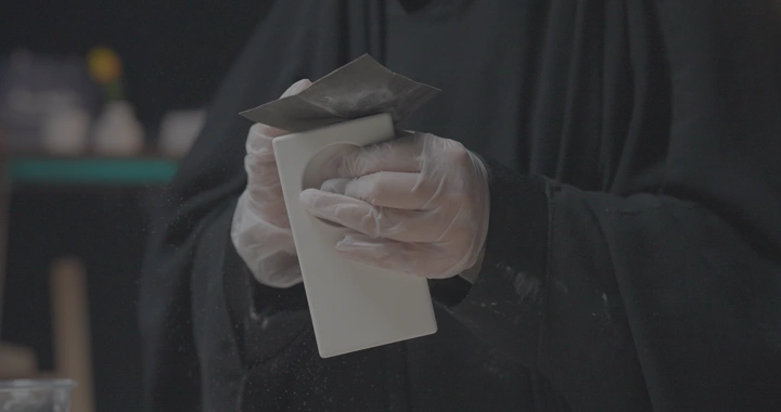 شخص يصنفر قطعة مصنوعة من الجبس في ورشة، لقطة قريبة.