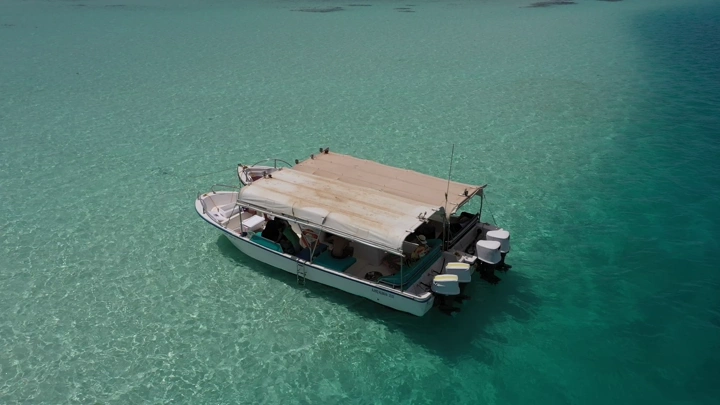 قارب في مياه زرقاء صافية في أملج، لقطة جوية.