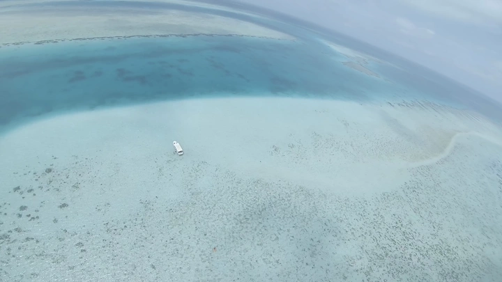 قارب في مياه زرقاء صافية في أملج، لقطة جوية.