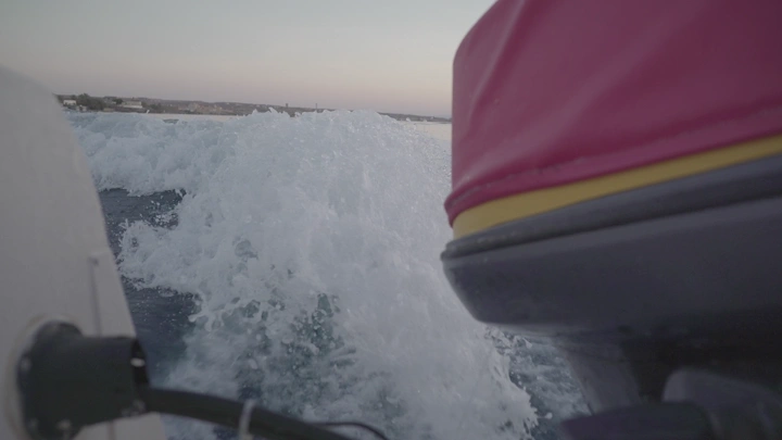 قارب سريع في البحر عند الغروب، لقطة مقربة.