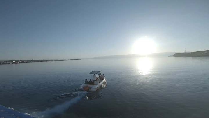 قارب صغير في مياه محافظة حقل عند غروب الشمس، لقطة جوية.