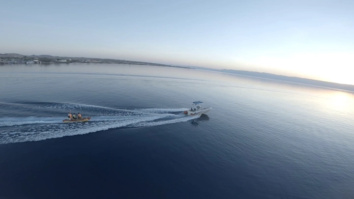 قارب سريع يسحب قارب مطاطي في مياه محافظة حقل، لقطة جوية.