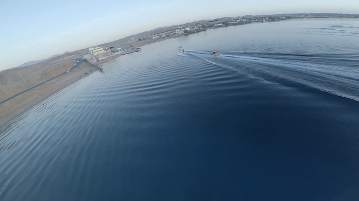 قارب سريع يسحب قارب مطاطي في مياه محافظة حقل، لقطة جوية.