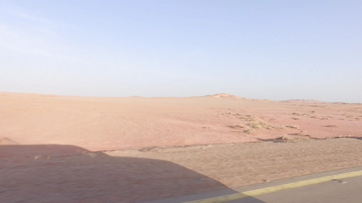 طريق صحراوي في وضح النهار، لقطة من السيارة.