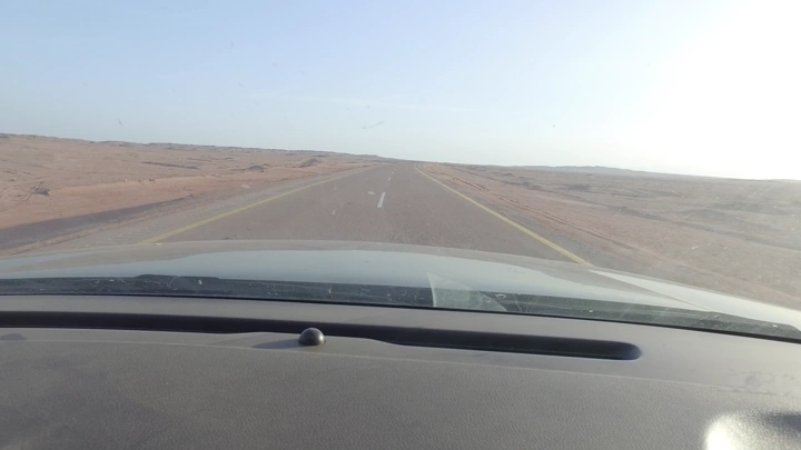 طريق صحراوي مفتوح في النهار، منظر من داخل السيارة.