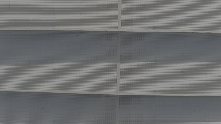 سوق التمر في القصيم، مشهد جوي نهاري يعرض السيارات والمظلات.