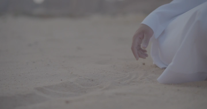 يد تلمس الرمال في الصحراء، لقطة قريبة.