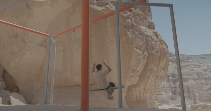 شخص على مرجيحة في جبال العلا، لقطة نهارية.