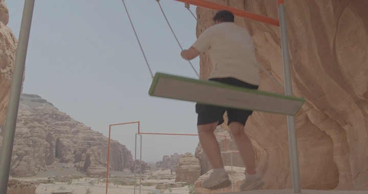 شخص يتأرجح في مرجيحة بين جبال العلا، لقطة نهارية.