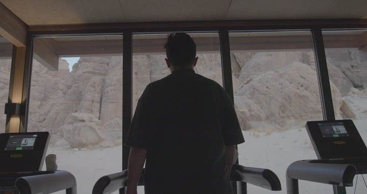 رجل على جهاز سير في العلا، لقطة داخلية.