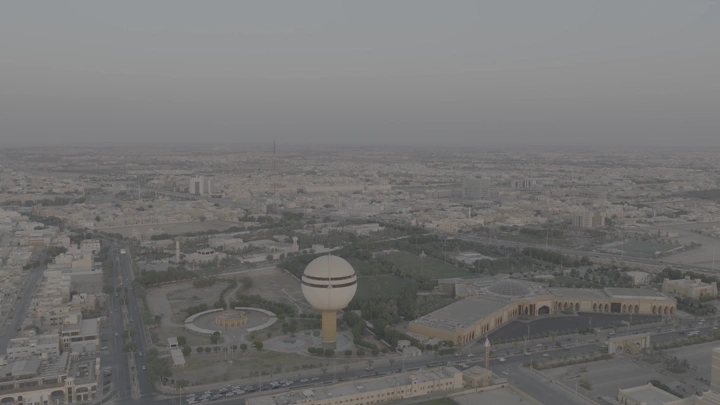 برج مياه بريدة وحديقة الملك خالد في القصيم، لقطة جوية عند الغروب.