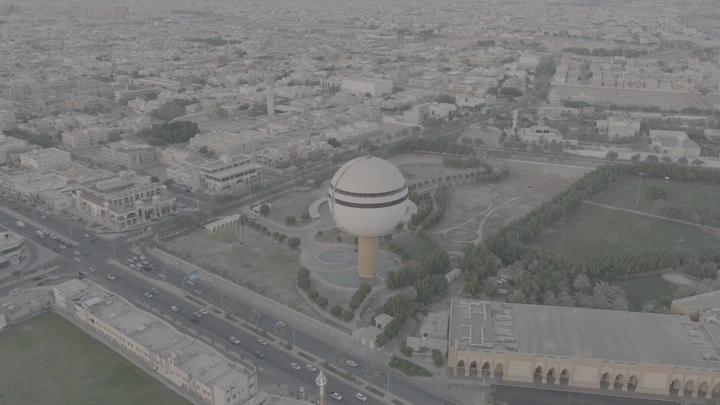 برج مياه بريدة في القصيم مع ظهور المدينة، لقطة جوية نهارية.