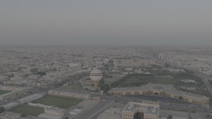 برج مياه بريدة وحديقة الملك خالد في القصيم، لقطة جوية عند الغروب.