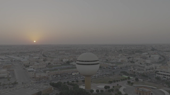 برج مياه بريدة في القصيم عند غروب الشمس، لقطة جوية واسعة.