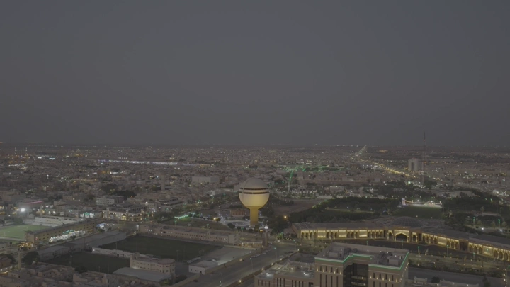 برج مياه بريدة ومركز الملك خالد الحضاري ومبنى أمانة المنطقة في القصيم، لقطة جوية مساءً.