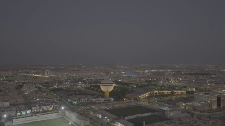 برج مياه بريدة ومركز الملك خالد الحضاري ومبنى أمانة المنطقة في القصيم، لقطة جوية ليلية.