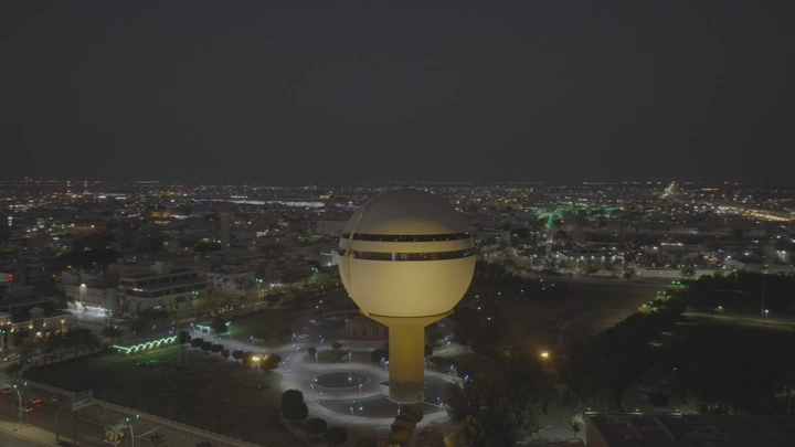 برج مياه بريدة مضاء ليلاً، لقطة جوية.