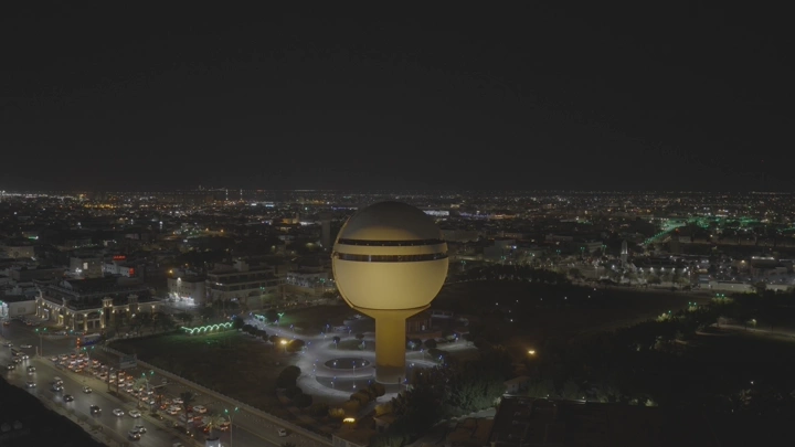 برج مياه بريدة في الليل، لقطة جوية تظهر الشوارع المحيطة.