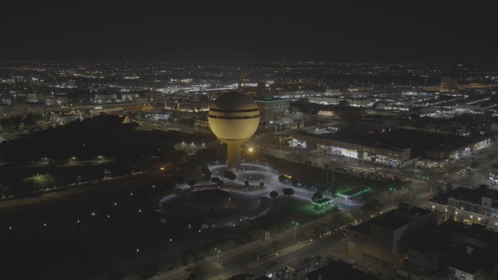 برج مياه بريدة ومركز الملك خالد الحضاري ومبنى أمانة المنطقة في القصيم مضاء ليلاً، لقطة جوية.