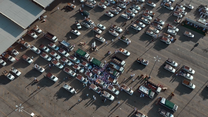 سوق تمور مزدحم في بريدة، لقطة جوية نهارية.